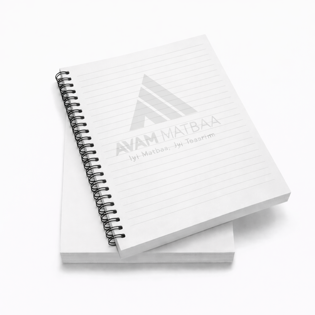 Siyah spiral ciltli, çizgili Avam Matbaa notluk baskısı açık gri zeminde üst üste yerleştirilmiş şekilde sergileniyor.